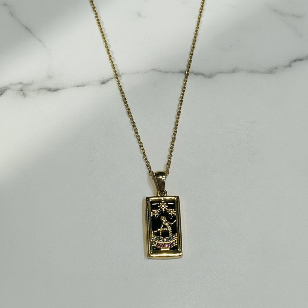 Gold necklace with a pendant on a light gray background