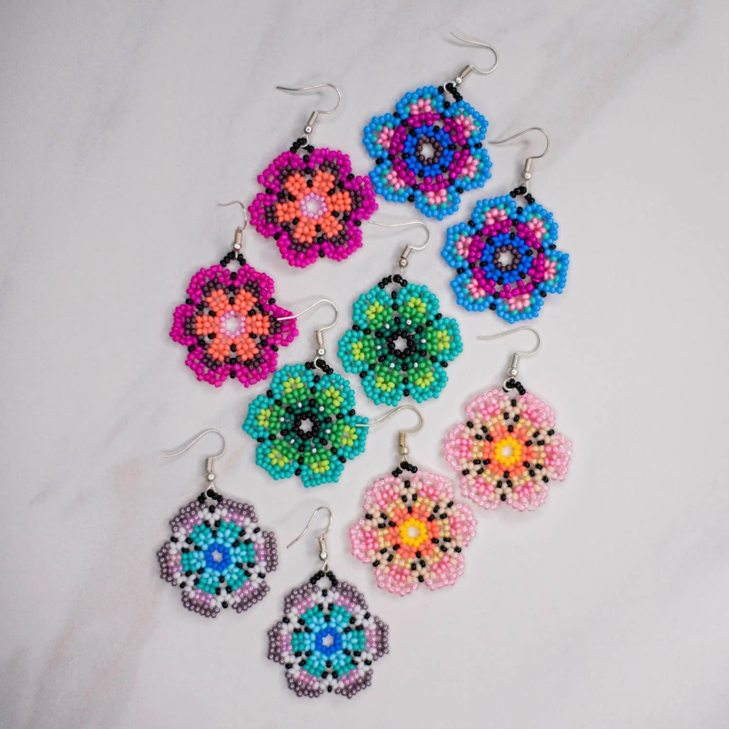 Colorful beaded flower earrings on a light gray background